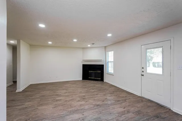 a view of empty room with wooden floor and fireplace