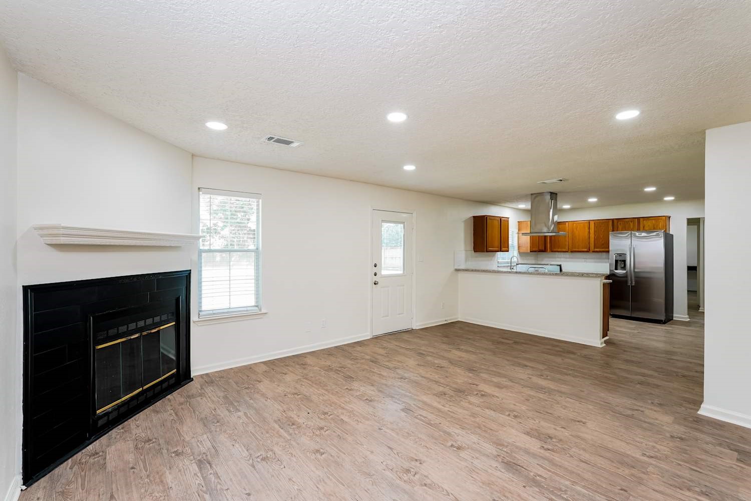 34306 Conroe Huffsmith Road Magnolia, TX 77354 - Photo 5 of 17 a view of kitchen and empty room with wooden floor