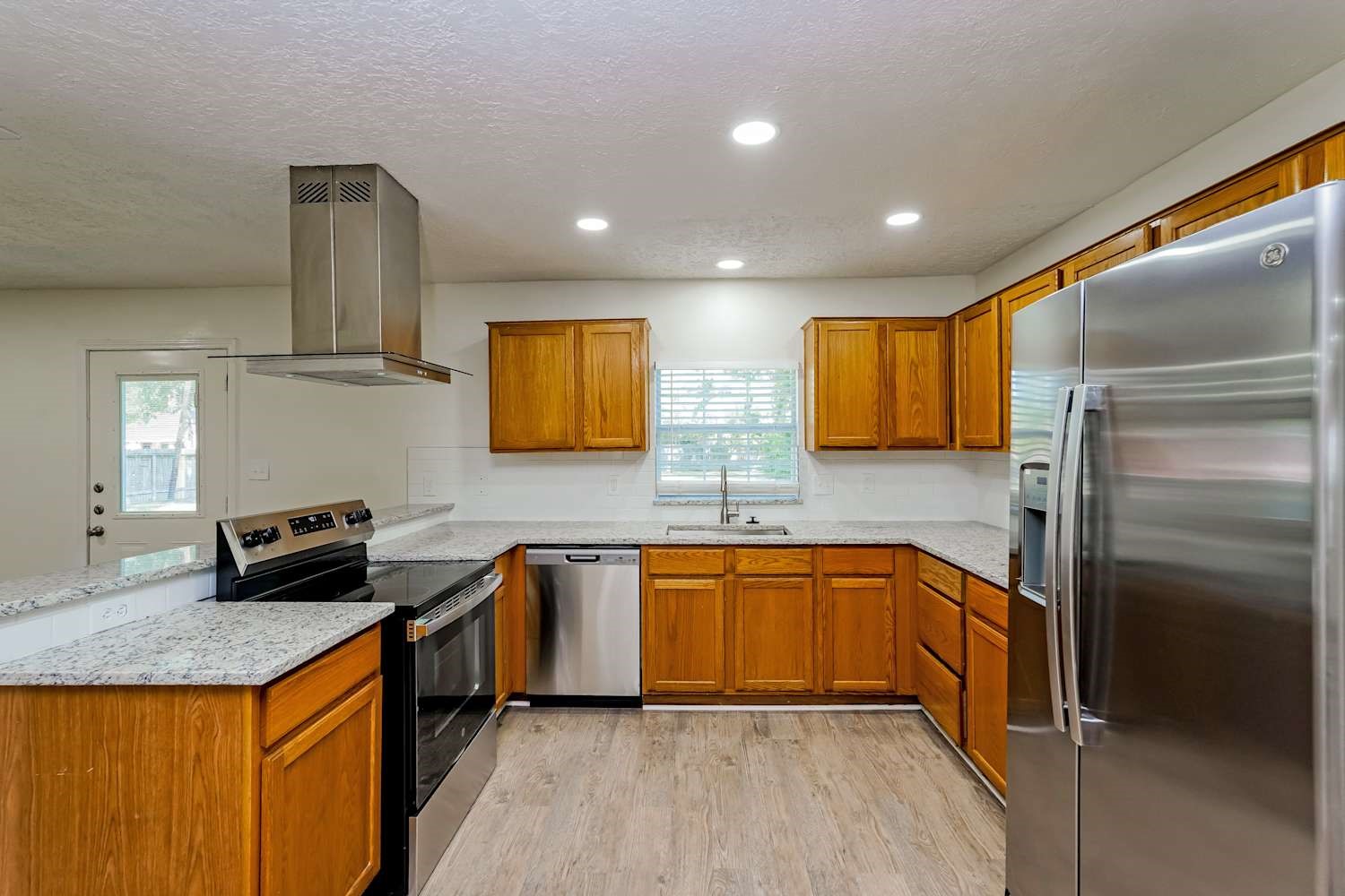 34306 Conroe Huffsmith Road Magnolia, TX 77354 - Photo 7 of 17 a kitchen with stainless steel appliances granite countertop sink stove top oven and refrigerator