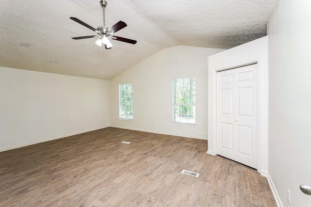 a view of a livingroom with a ceiling fan window and wooden floor