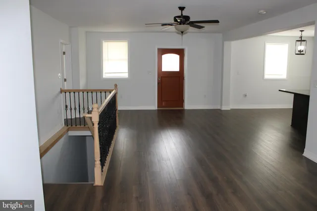 a view of a hallway with wooden floor and windows