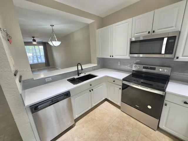 a kitchen with a sink and stainless steel appliances