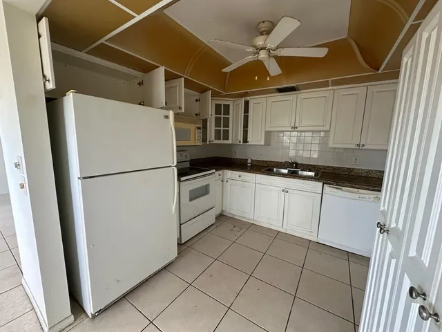 a kitchen with white cabinets and white appliances