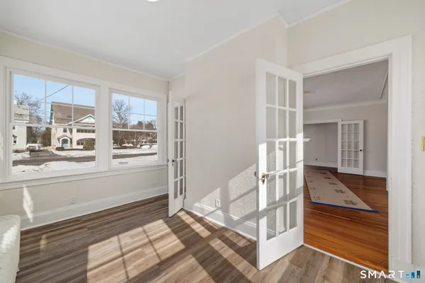 a view of empty room with a window and wooden floor