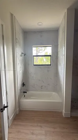 an empty room with wooden floor and entrance