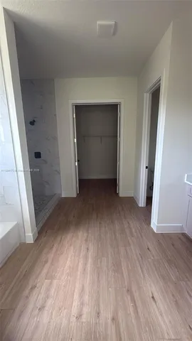 a view of empty room with wooden floor