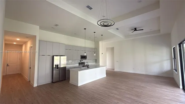 a view of a kitchen with a refrigerator a microwave and a sink
