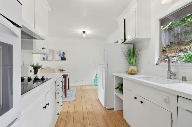 a kitchen with white cabinets and appliances