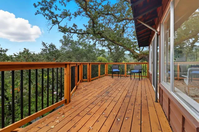 a view of balcony with wooden floor and fence