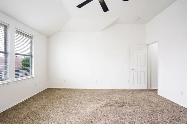 an empty room with a window and a ceiling fan