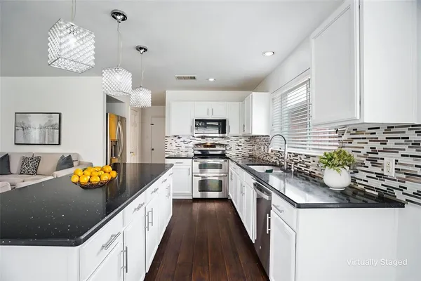 a kitchen with granite countertop lots of counter top space and stainless steel appliances