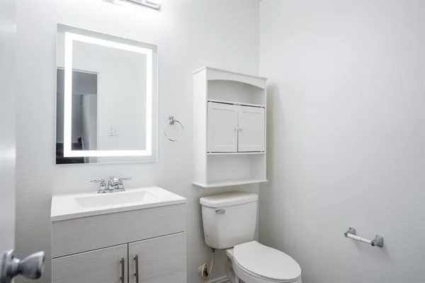 a bathroom with a toilet sink and mirror