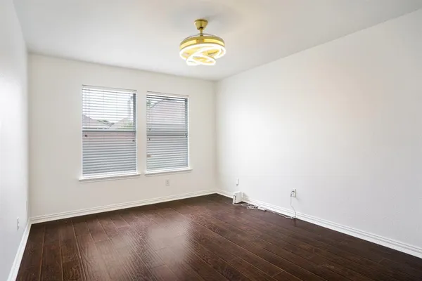 an empty room with wooden floor and a window