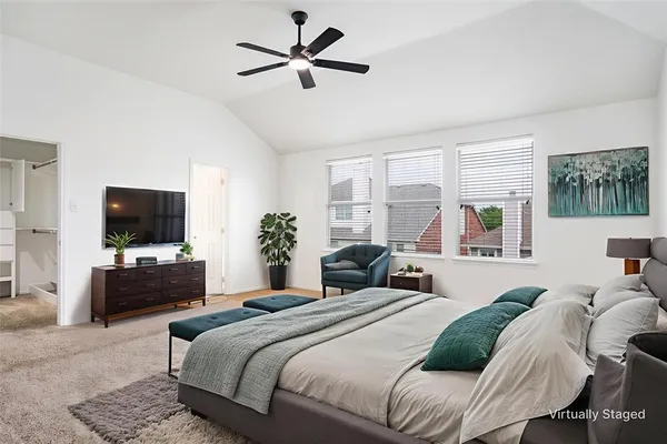 a bedroom with a bed a couch and a flat screen tv