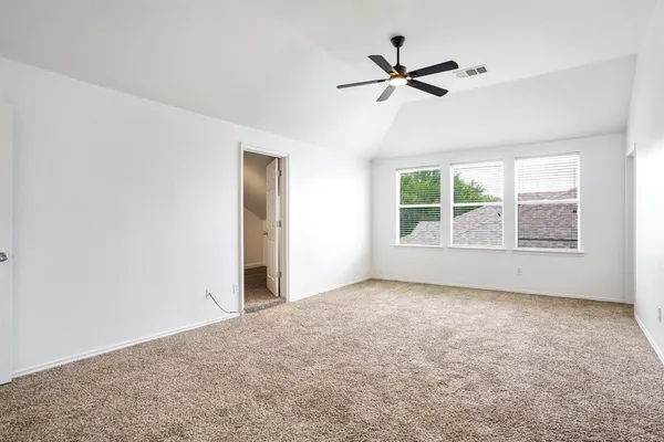 an empty room with windows and fan