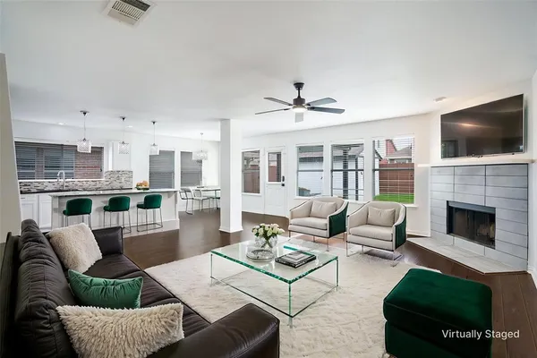 a living room with furniture a flat screen tv and a fireplace