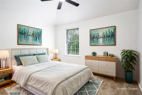 a bedroom with a large bed and a chandelier