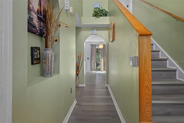 a view of a hallway with wooden floor and a livingroom view