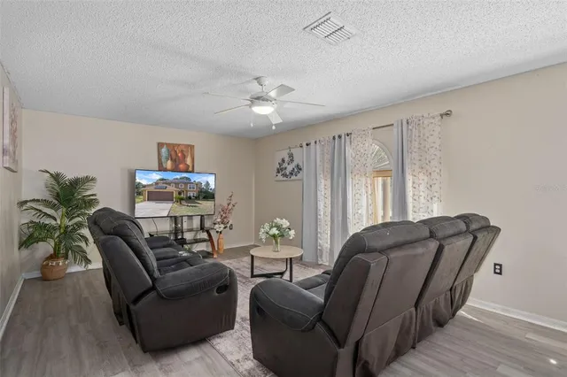 a living room with furniture and a wooden floor