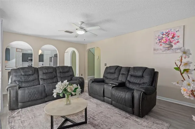 a kitchen with stainless steel appliances granite countertop a refrigerator a sink dishwasher a stove and white countertops with wooden floor