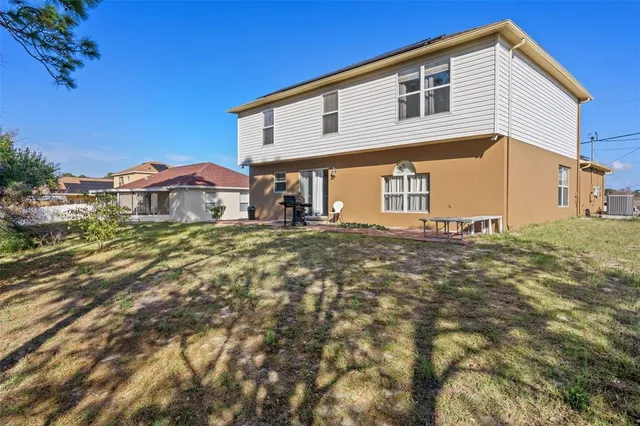a backyard of a house with table and chairs