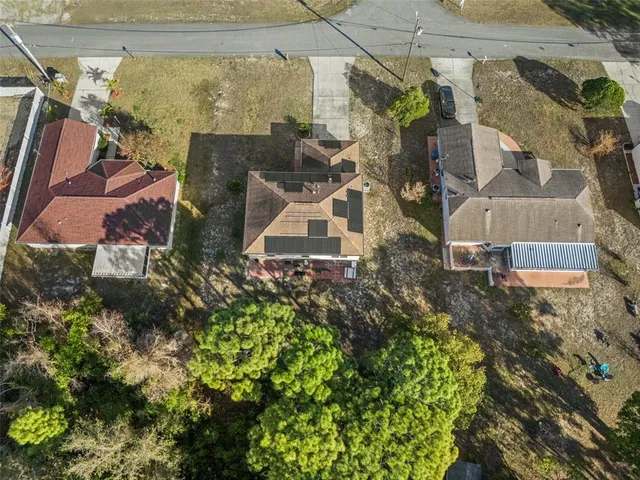an aerial view of a house with a yard and large tree