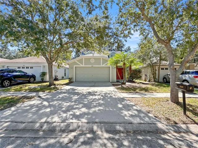 a front view of a house with a yard and parking