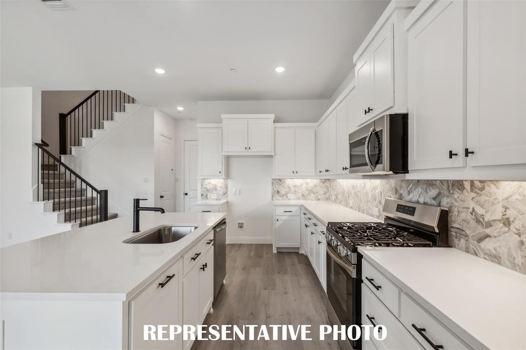 1331 Rooted Road Frisco, TX 75033 - Photo 7 of 14 Beautiful cabinetry, gorgeous countertops and designer backsplash paired with contemporary stainless steel come together to create the kitchen of your dreams in our Helaina plan! REPRESENTATIVE PHOTO