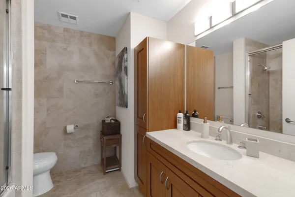 a bathroom with a double vanity sink toilet and shower