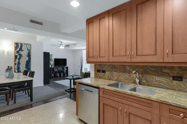 a kitchen with stainless steel appliances granite countertop a sink dishwasher stove and cabinets with wooden floor