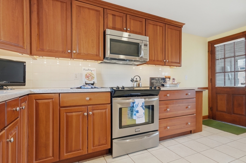 16 Cheswick Road Arlington, MA 02474 - Photo 11 of 35 a kitchen with stainless steel appliances granite countertop a stove microwave and cabinets