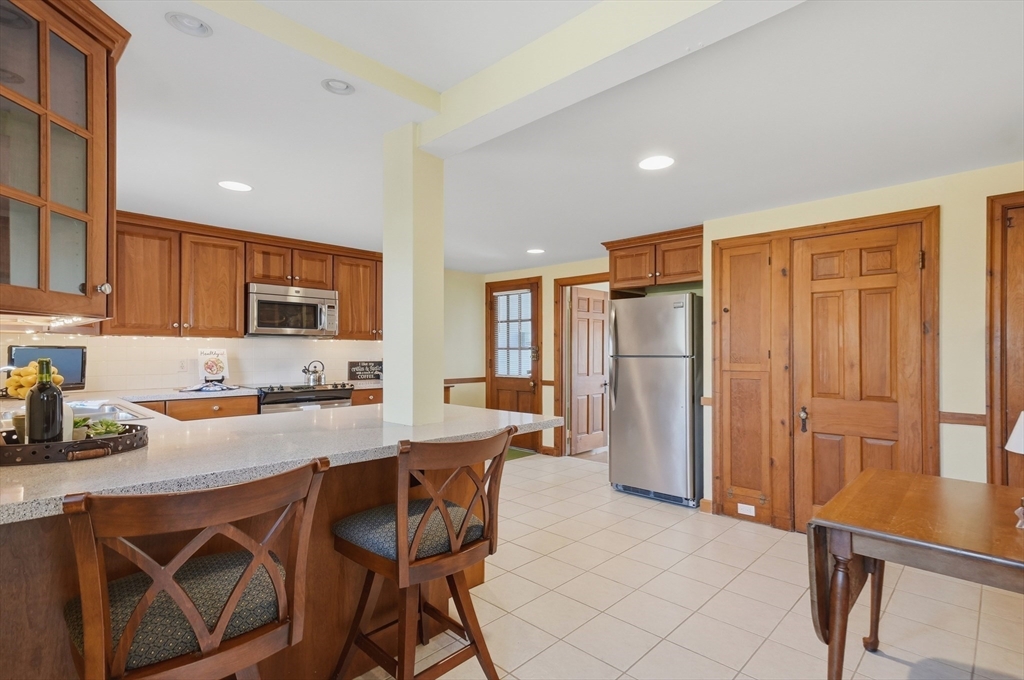 16 Cheswick Road Arlington, MA 02474 - Photo 12 of 35 a kitchen with stainless steel appliances granite countertop a refrigerator and a stove top oven