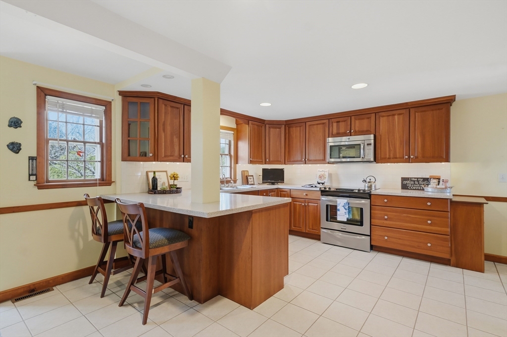 16 Cheswick Road Arlington, MA 02474 - Photo 15 of 35 a kitchen with stainless steel appliances granite countertop a table chairs sink and cabinets