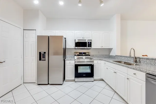 a kitchen with stainless steel appliances granite countertop a refrigerator sink and stove