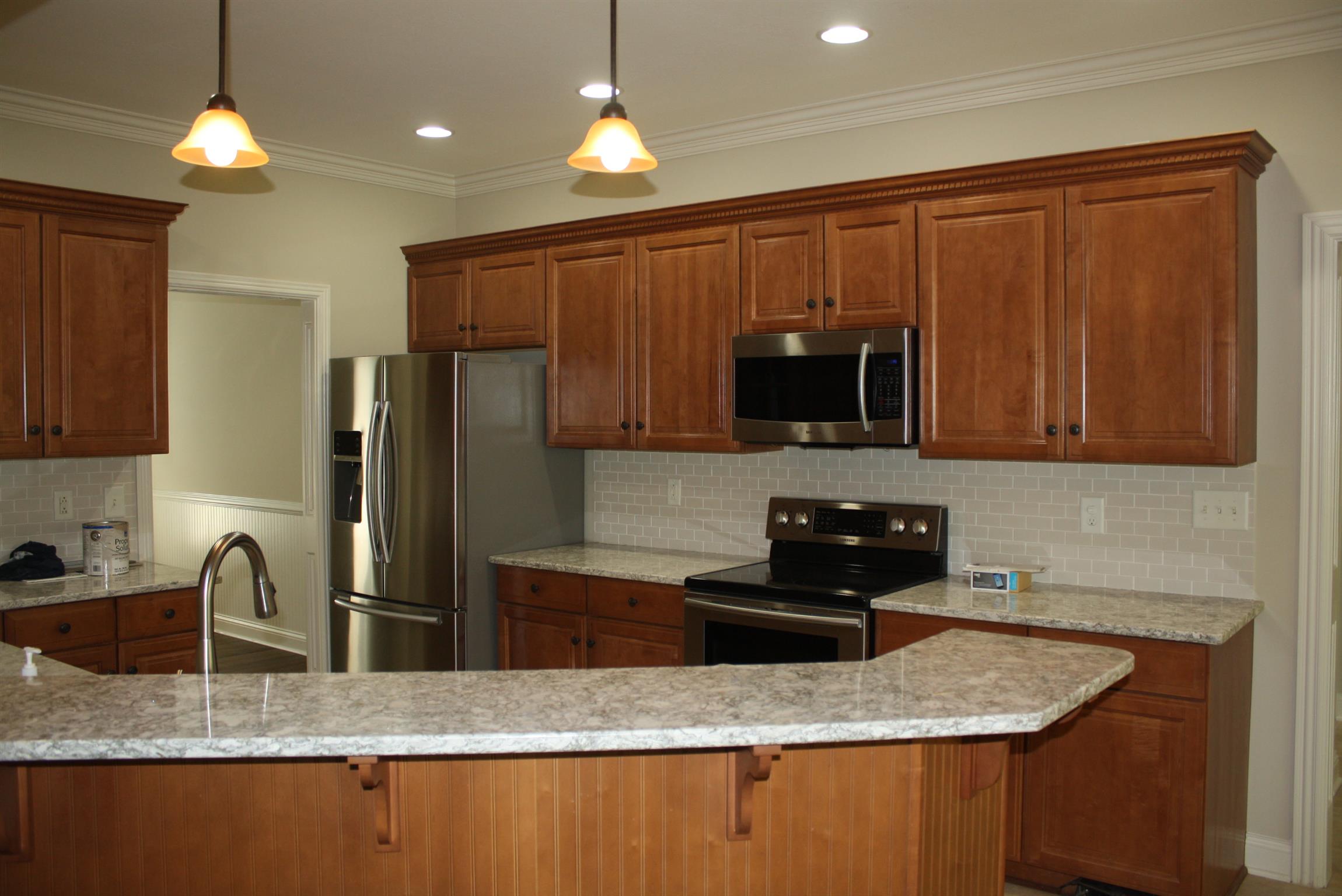 3620 Guthrie Road Clarksville, TN 37043 - Photo 8 of 30 a kitchen with granite countertop stainless steel appliances a refrigerator a sink a stove a dining table and chairs with wooden floor