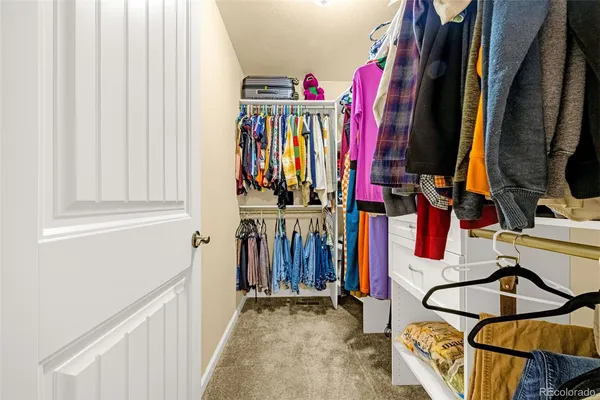 a view of walk in closet with clothes