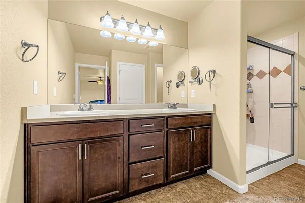 a bathroom with a granite countertop sink a mirror and a shower