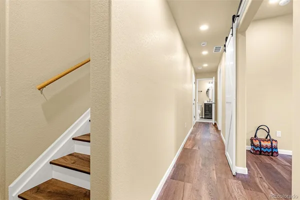 a view of a hallway with wooden floor and staircase