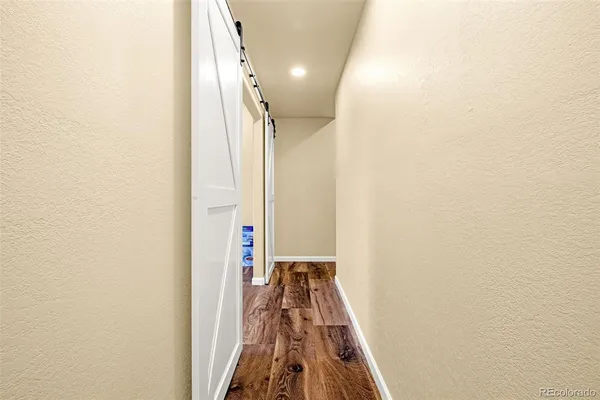 a view of a hallway with wooden floor and staircase