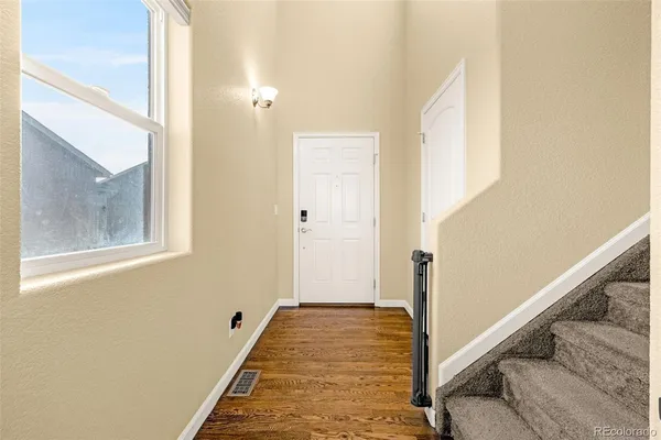 a view of a hallway with wooden floor and staircase