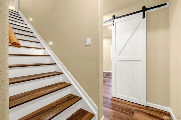 a view of staircase with wooden floor and white walls