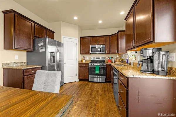 a kitchen with stainless steel appliances granite countertop a stove a sink and a refrigerator
