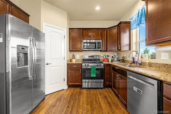 a kitchen with stainless steel appliances a refrigerator a sink a stove and cabinets