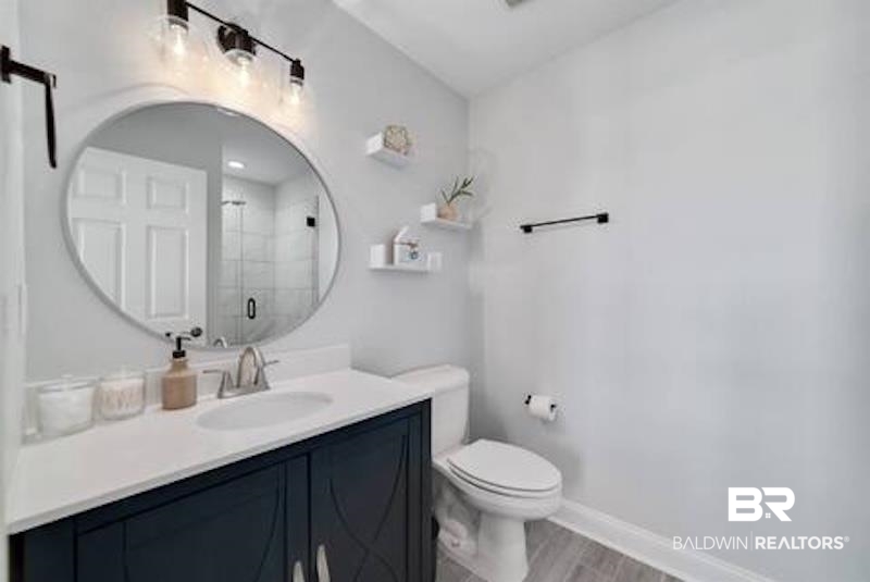 1492 Shell Lane Gulf Shores, AL 36542 - Photo 11 of 20 Bathroom with vanity, a shower stall, and wood finished floors