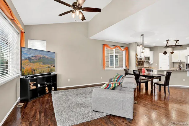 a dining room with stainless steel appliances kitchen island granite countertop a dining table chairs and a refrigerator