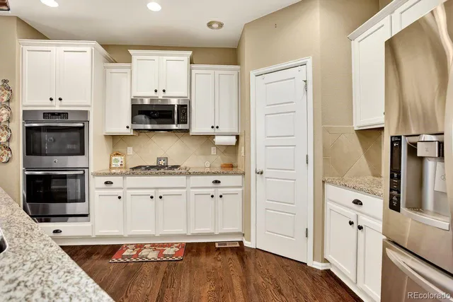 a dining room with wooden floor a chandelier a wooden table and chairs