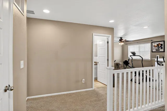 an empty room with a window and a ceiling fan