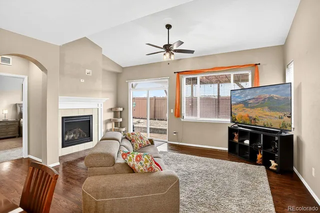a living room with furniture a fireplace and a floor to ceiling window