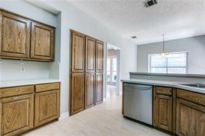 544 Lake Forest Drive Coppell, TX 75019 - Photo 11 of 24 a kitchen with white cabinets and a refrigerator