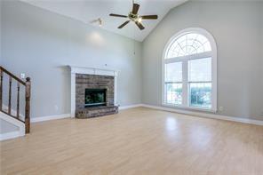 544 Lake Forest Drive Coppell, TX 75019 - Photo 14 of 24 an empty room with windows fireplace and fan